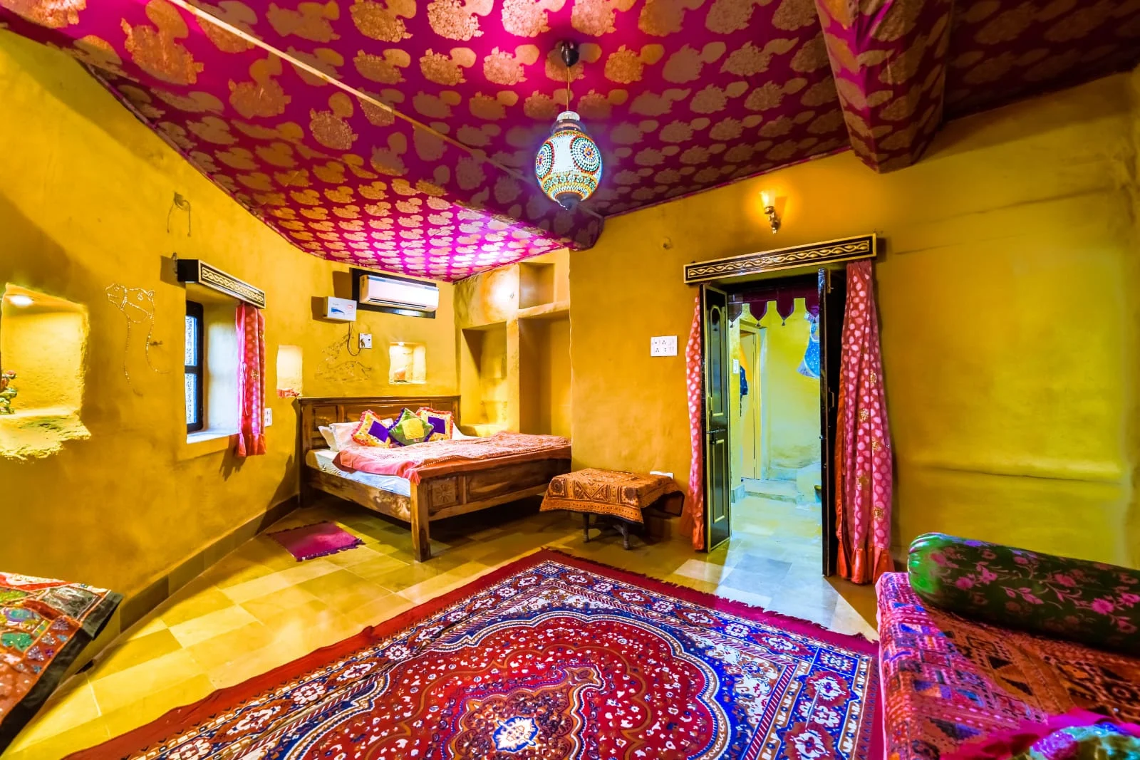 A room with warm walls and a patterned fabric canopy
